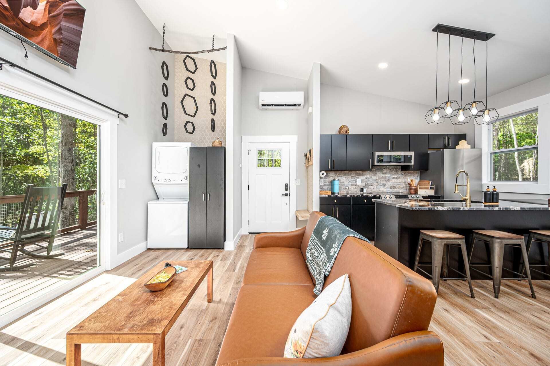 A modern kitchen with dark cabinets, a central island, and a built-in microwave.