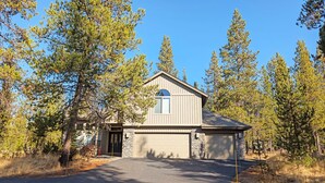 Une maison de plain-pied avec des fondations en pierre, un garage et une allée menant à l’entrée.