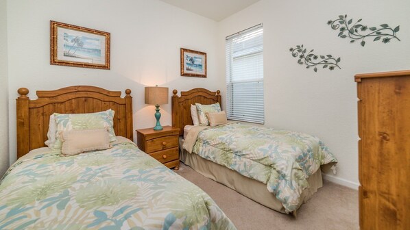 A bedroom with two single beds, a nightstand with a lamp, and a window with blinds. - Cw7730 Windsor Hills Resort Vacation Home (Kissimmee)
