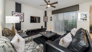 A modern living room with a sofa set, a coffee table, a TV, and artwork on the walls. - Ctd4741-102 (Kissimmee)