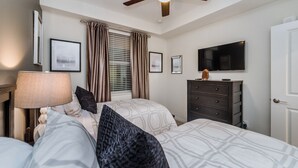 A bedroom with two beds, a dresser, a television, and a ceiling fan. - Ctd4741-102 (Kissimmee)