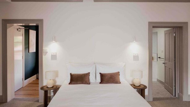 Une chambre à coucher avec un grand lit, deux lampes de chevet et une table de chevet avec une lampe.