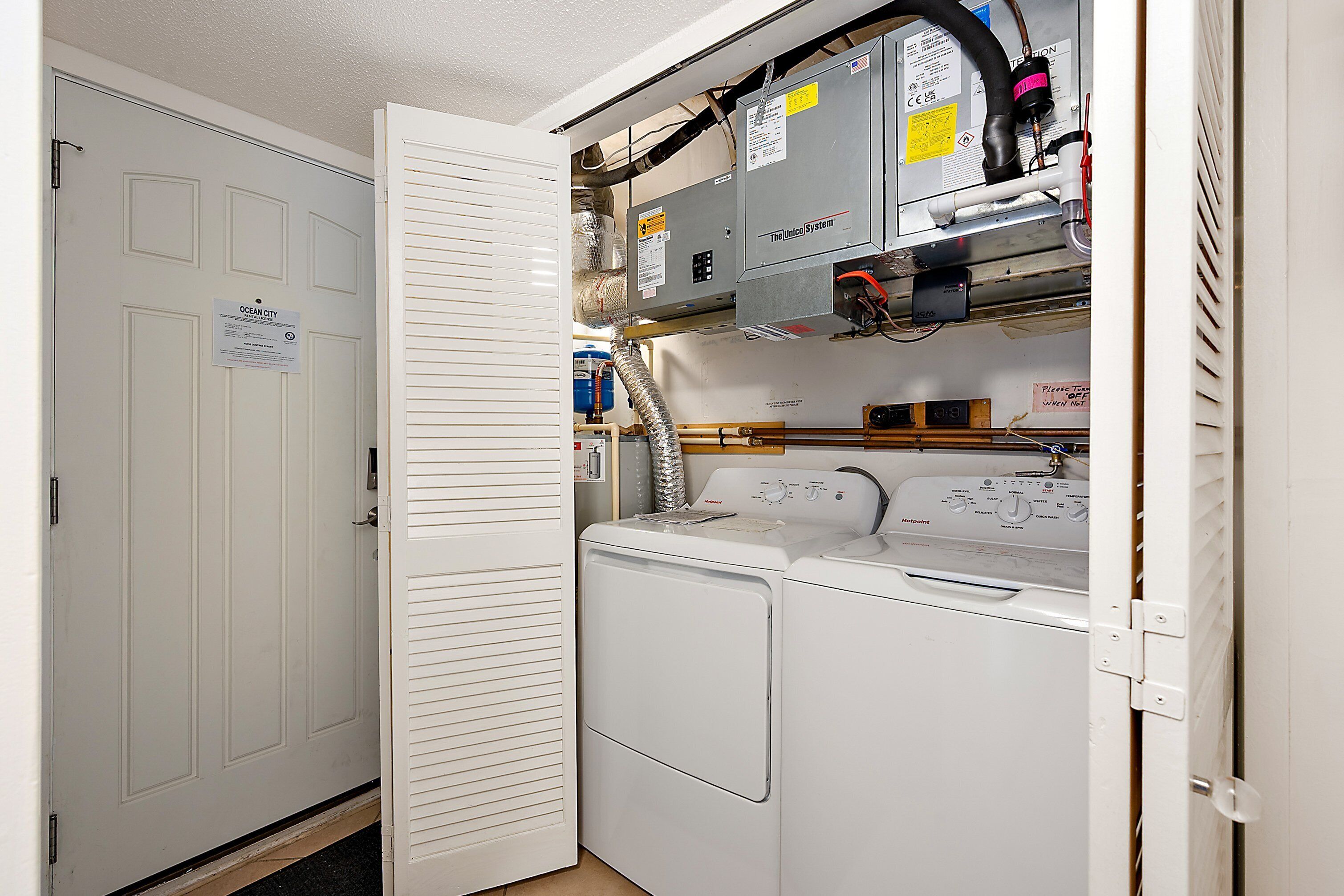 A laundry room with a washing machine and dryer, a utility room with electrical panels, and a door labeled "Ocean City."