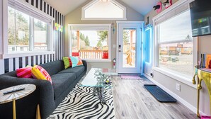 A modern living room with a sofa, zebra-patterned rug, and a glass coffee table.