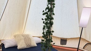 A tent with a bed, a lamp, and a heater. - Glamping Tent in Red River Gorge w/ Heater and Hot Tub (Stanton)