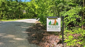 A sign for 'The Retreat at High Rock Creekside Bunkhouse' with a rustic cabin illustration. - Glamping Tent in Red River Gorge w/ Heater and Hot Tub (Stanton)