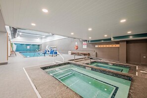 An indoor swimming pool with multiple lanes, a lifebuoy, and a bench. - Fully Renovated Upscale Condo, Walk to Snowshed, Amenities Downstairs (Killington)