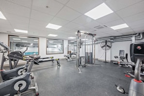 A gym with various exercise equipment, including treadmills, a rowing machine, and weightlifting stations. - Fully Renovated Upscale Condo, Walk to Snowshed, Amenities Downstairs (Killington)
