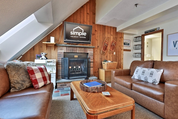 Welcoming living space with an electric fireplace and seating arranged for conversation, games, or relaxing after a day on the mountain.