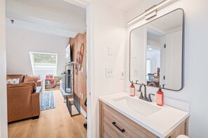 Une salle de bain moderne avec un grand miroir, deux lavabos et un meuble en bois.