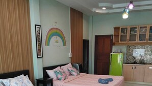 Quarto com duas camas, uma kitchenette e um banheiro.