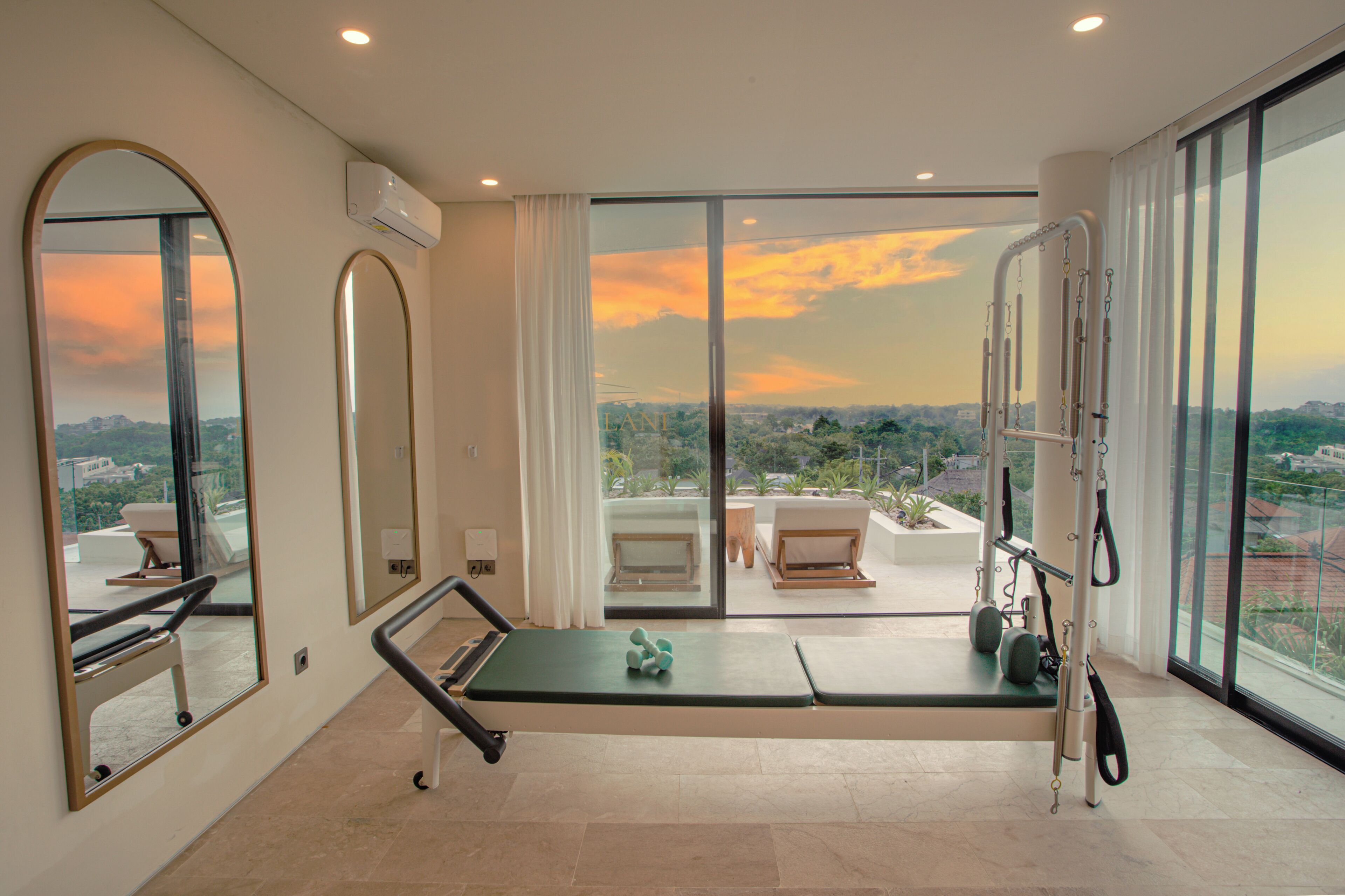 A modern room with a large window, exercise equipment, and a view of the city.