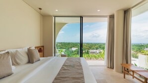 A hotel room with a large bed, a wooden bench, and a view of a lush landscape through a sliding glass door. - Villa Kalani Spirit by Alfred in Bali (Pecatu)