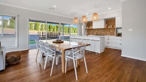 A modern kitchen with a central island, white cabinetry, and pendant lighting.