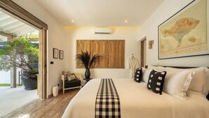 A spacious bedroom with a large bed, a map on the wall, and a view of the outdoors. - Villa Luxe Bali 1 (Seminyak)