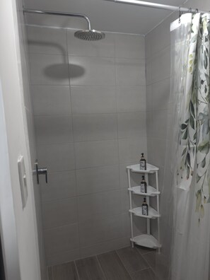 Een douche, milieuvriendelijke toiletartikelen, handdoeken, zeep
