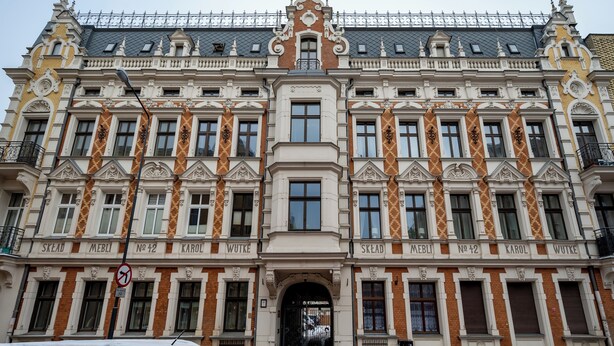 Ein historisches Gebäude mit aufwändiger Architektur, darunter ein markanter Eingang und mehrere Fenster.
