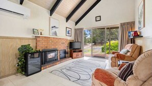A living room with a fireplace, a television, and a sofa.