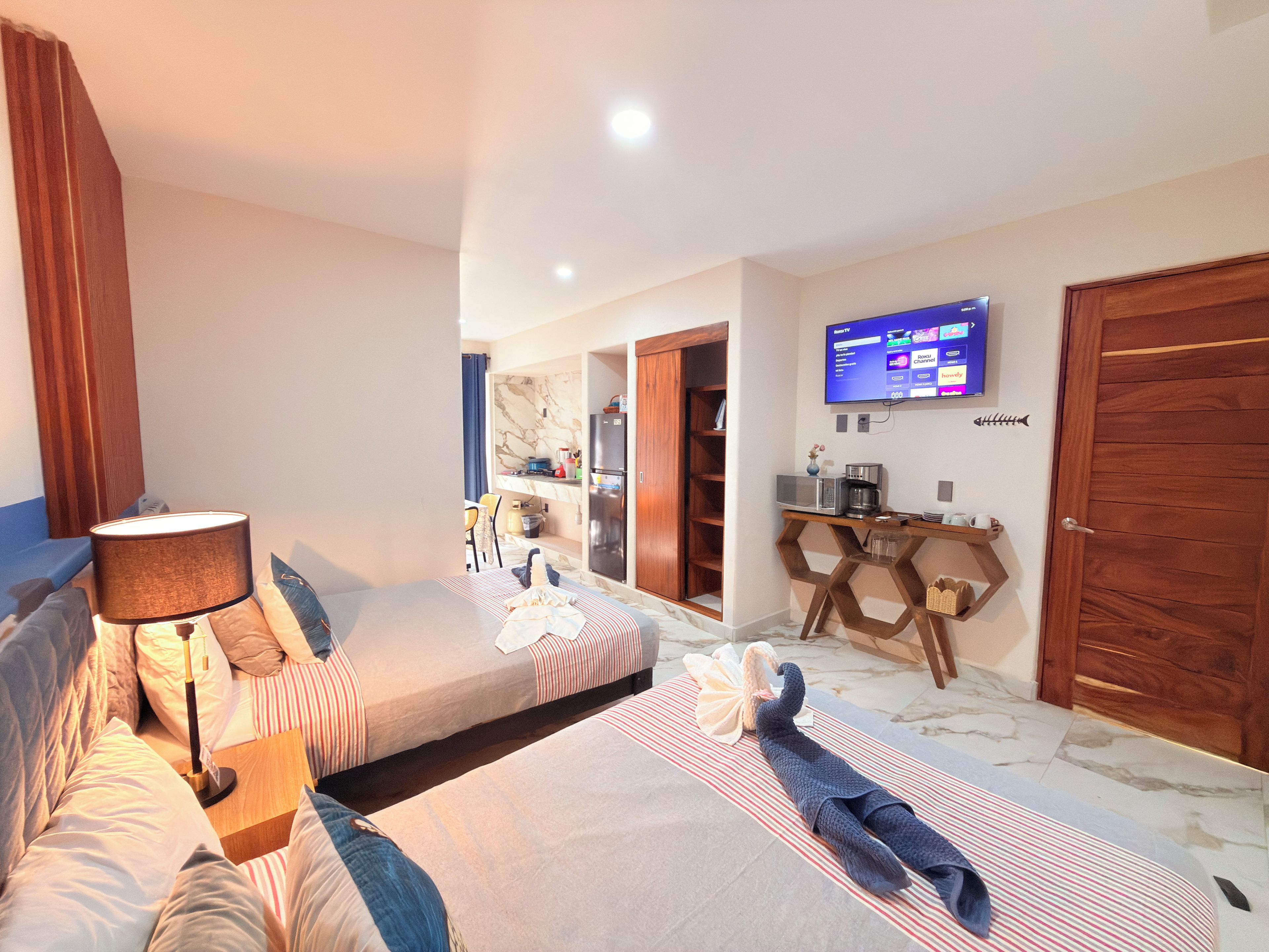 A hotel room with a bed, a desk, a television, and a wardrobe.