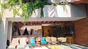 A modern building with a pool area, including lounge chairs and a bar. - Espacio Diez Hotel Boutique (Zihuatanejo)
