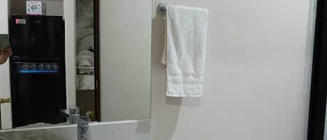 A bathroom with a white sink, a toilet, and a mirror.