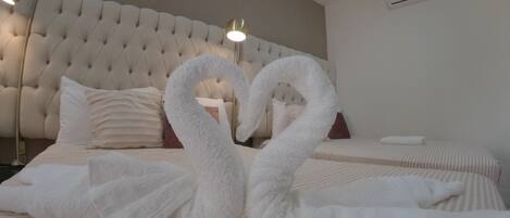 Una habitación de hotel con una cama grande, cabecera capitonada y aire acondicionado instalado en la pared.