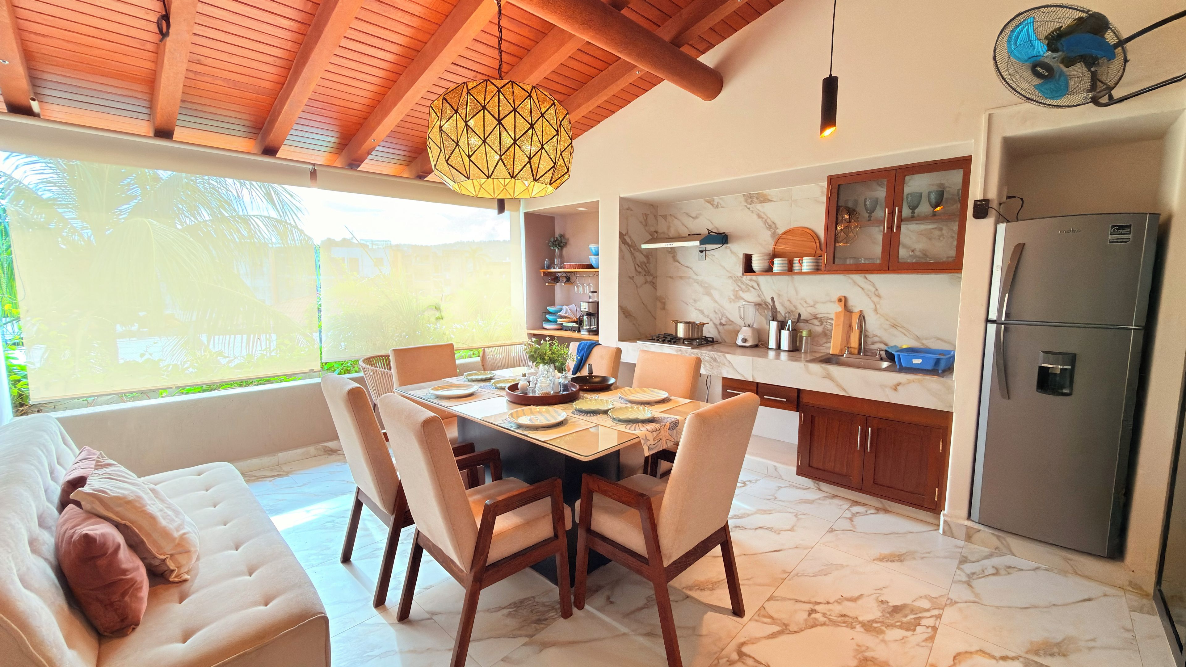 A modern kitchen with a marble countertop, wooden cabinets, and a built-in refrigerator.
