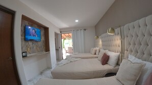 A hotel room with two beds, a television, and a view of the outdoors. - Espacio Diez Hotel Boutique (Zihuatanejo)