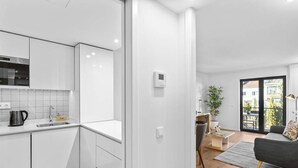 Un apartamento moderno con cocina, sala de estar y balcón.