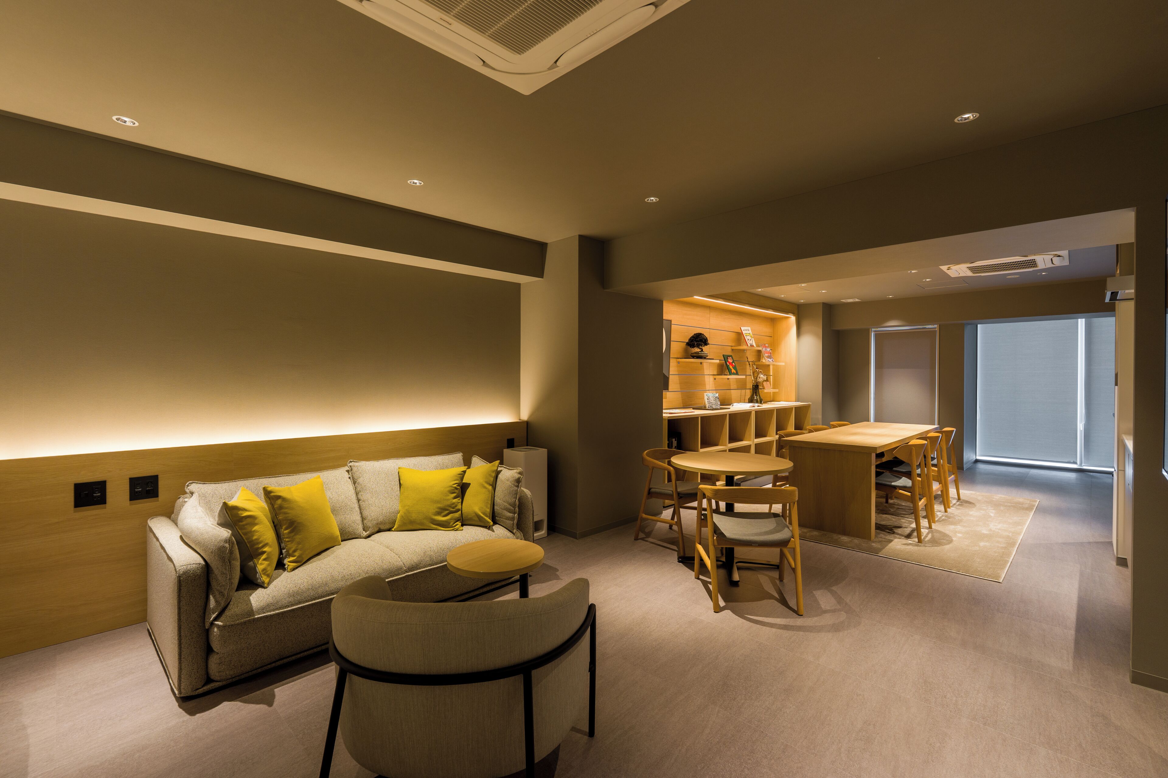 A modern living room with a sofa, coffee table, and dining area.