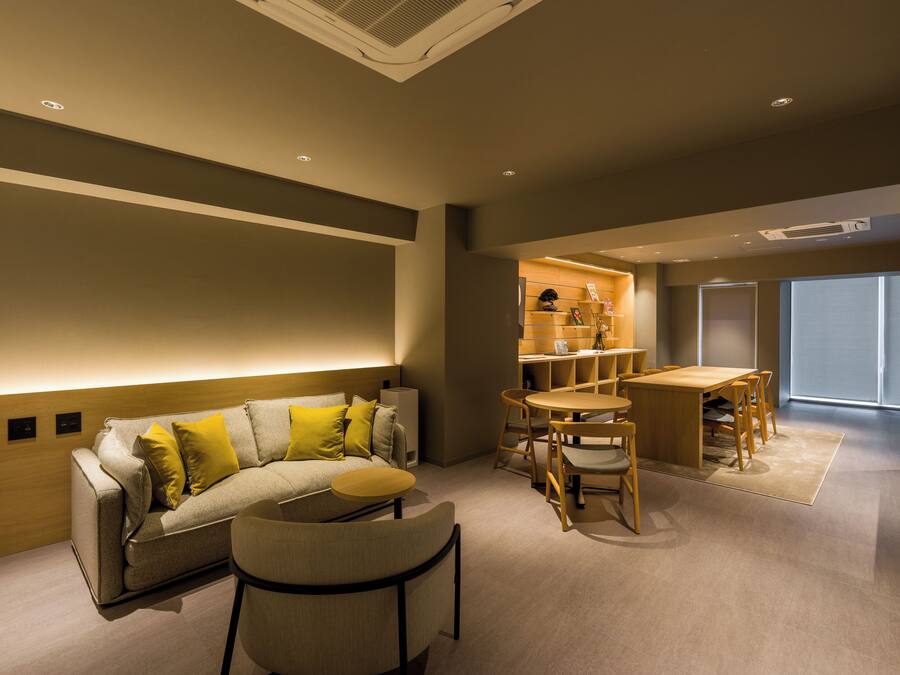 A modern living room with a sofa, coffee table, and dining area.