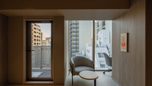 A modern apartment with a balcony, a chair, and a small table. - Sumu Ueno East (Tokyo)
