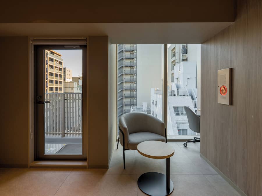 A modern apartment with a balcony, a chair, and a small table.