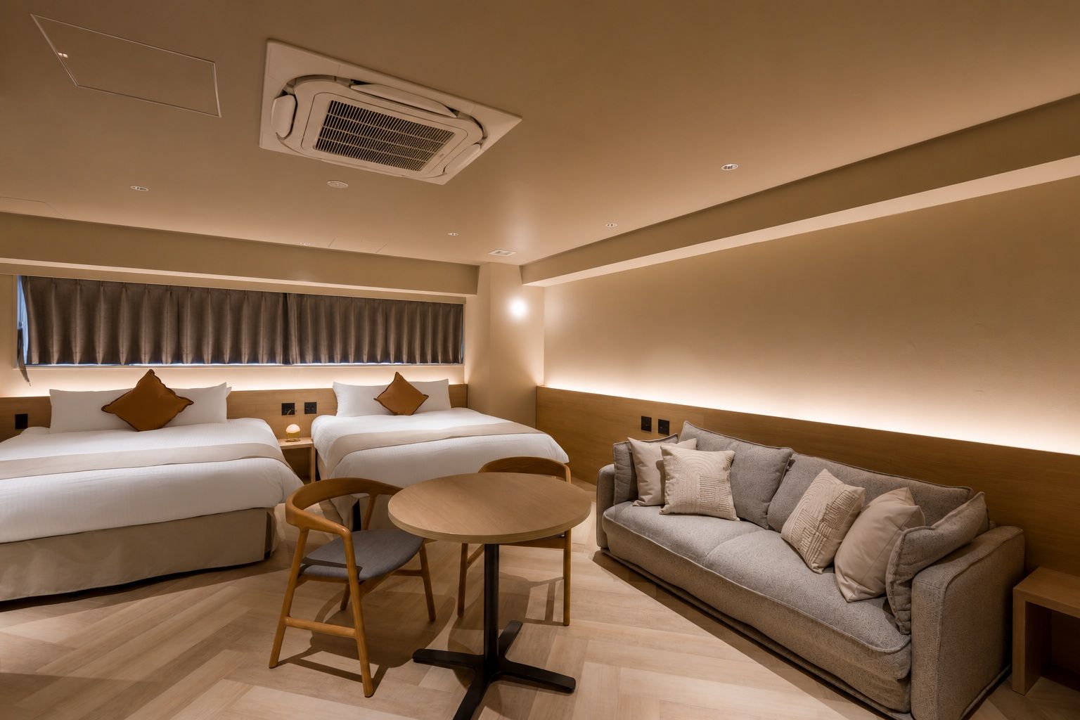 Une chambre d’hôtel comprenant un lit, deux tables de chevet, un canapé, une table ronde et une chaise.