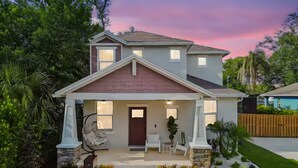 A two-story house with a front porch, a stone accent wall, and a well-maintained lawn. - Resort Pool & SPA , Mini Golf , Pool Table, Near Busch Gardens (Tampa)