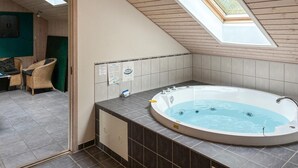 A modern bathroom with a freestanding bathtub, tiled walls, and a skylight. - Beautiful home in Idestrup with sauna (Idestrup)