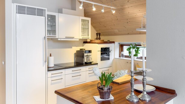 A modern kitchen with white cabinetry, a wooden countertop, and a built-in oven. - Awesome apartment in Væggerløse with WiFi (Væggerløse)