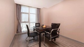 A small meeting room with a table, four chairs, a projector, and a window with curtains. - suzhouzhexujiajiudian (Suzhou)