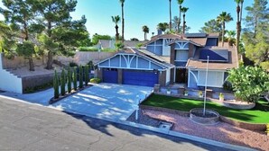 A two-story house with a garage, a front yard with a lawn, and a small fountain. - A -LV HOME PALM D (Las Vegas)