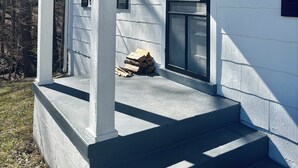 A white house with a porch, a door, and a window. - Quiet, Private Home in Kingston Springs for Two (Kingston Springs)