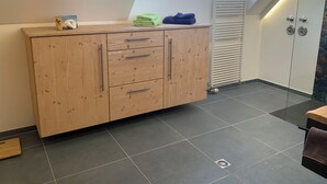 Une cuisine moderne avec des meubles en bois, une fenêtre et un radiateur.