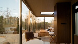 Un interior modern amb grans finestres, una zona d'estar acollidora i vistes a l'exterior.