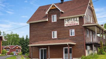 A two-story log cabin with a sign reading "Motel au Vieux Frontenac."