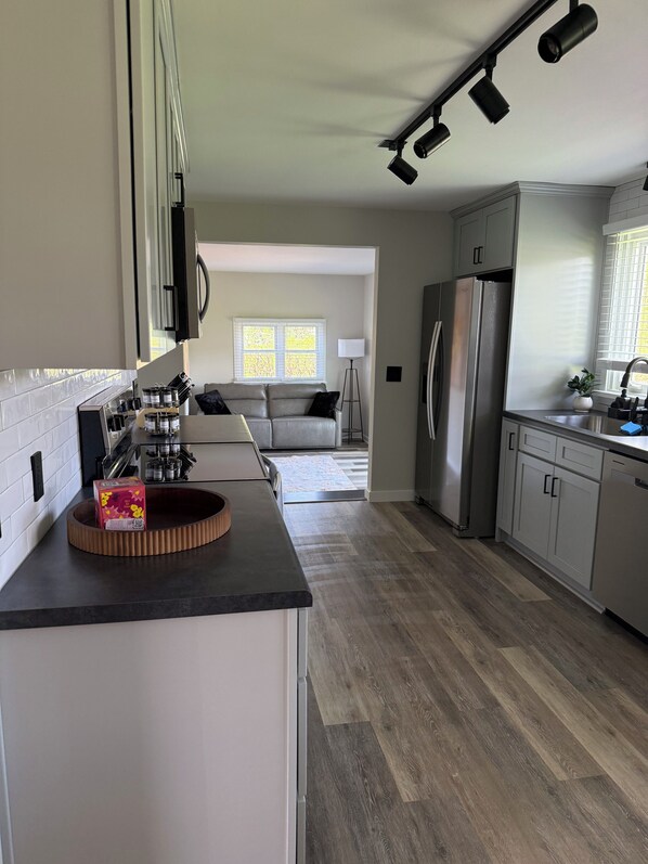 A modern kitchen with a built-in oven, a refrigerator, and a countertop with a coffee machine. - Cozy 3-bedroom house in lovely Rochester with AC and charm (Rochester)