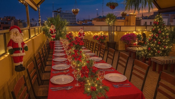 A rooftop dining area with a red tablecloth, Christmas decorations, and a Santa Claus figure.
