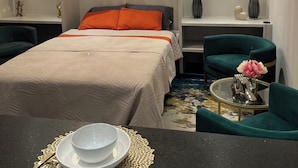 A modern hotel room with a large bed, a chandelier, an air conditioning unit, a framed picture on the wall, and a dining area with a table and chairs. - Beautiful, New,Clean,Luxurious Guest House in Great, safe location near consulate (Juárez)