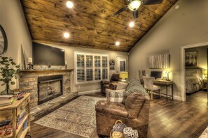 Smart-tv, een open haard, boeken en een computerscherm