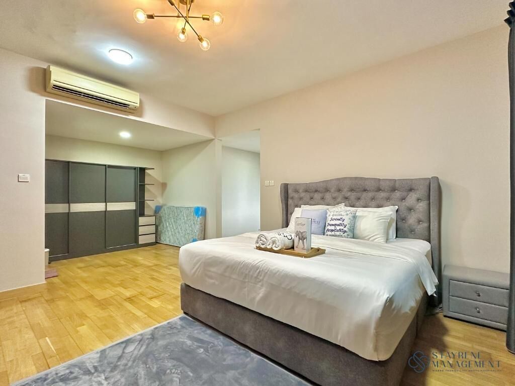 A bedroom with a large bed, a bedside table, a wardrobe, and a ceiling light fixture.