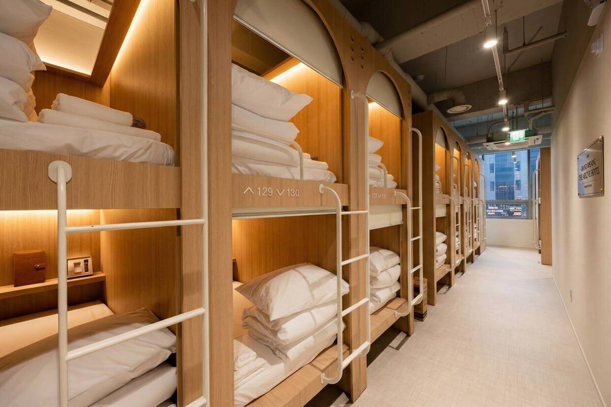 Una habitación de hotel con literas, cabeceros de madera y vistas a la ciudad.