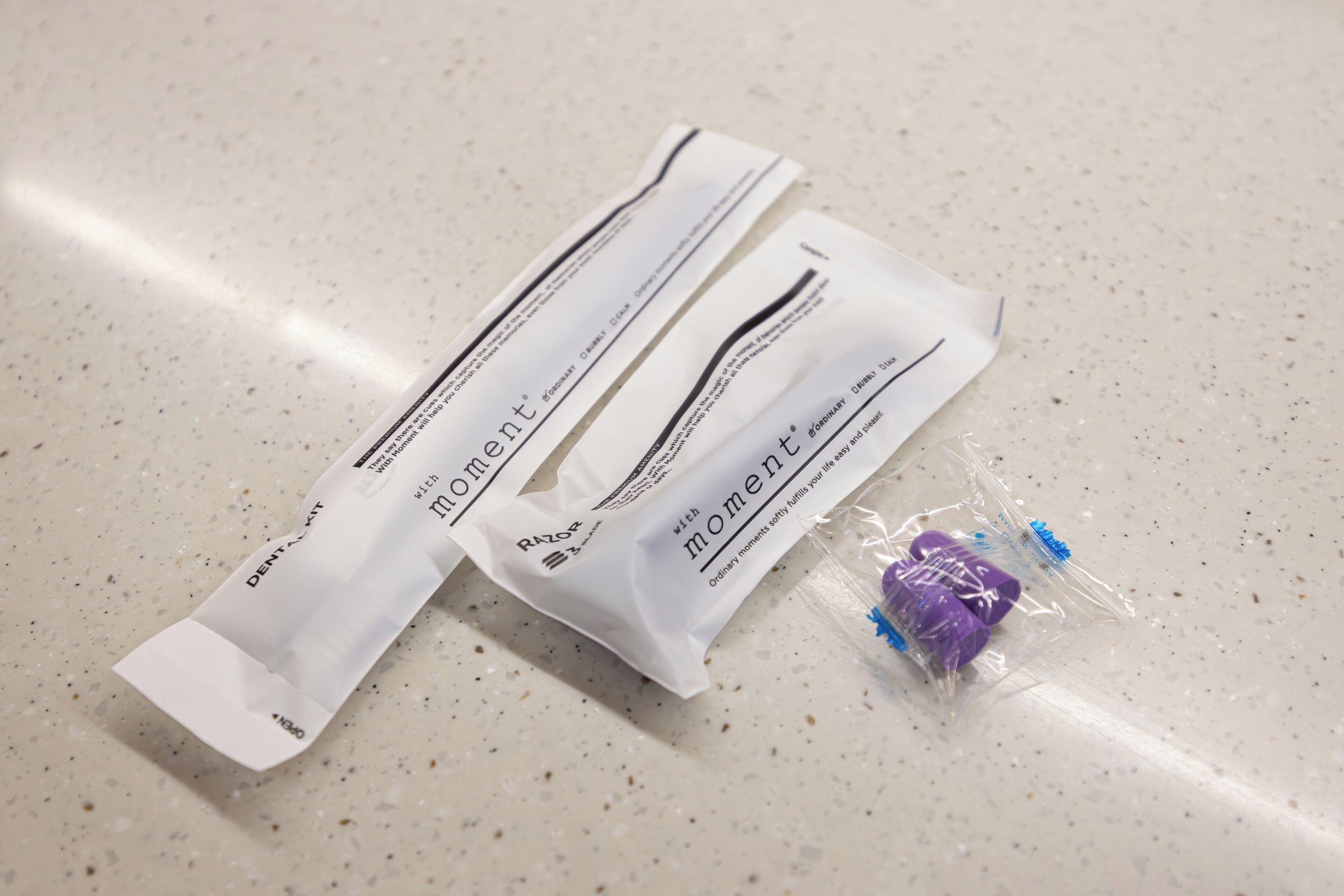 Deux emballages étiquetés « Moment » et « Razor » sont posés sur un comptoir à motifs.